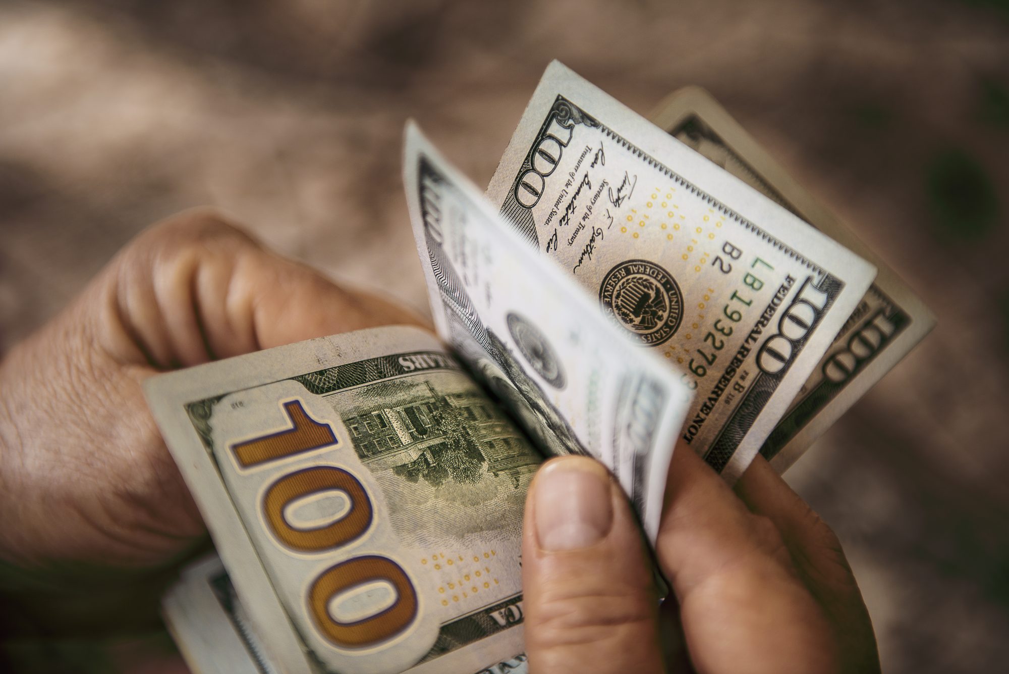 Unrecognizable mature man counting USA one hundred Dollar bills. High angle view. Horizontal composition. Image taken with Nikon D800 and developed from RAW format.
